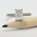 Front view of 14kt white gold engagement ring with radiant lab diamond and pave-set diamonds, next to pencil