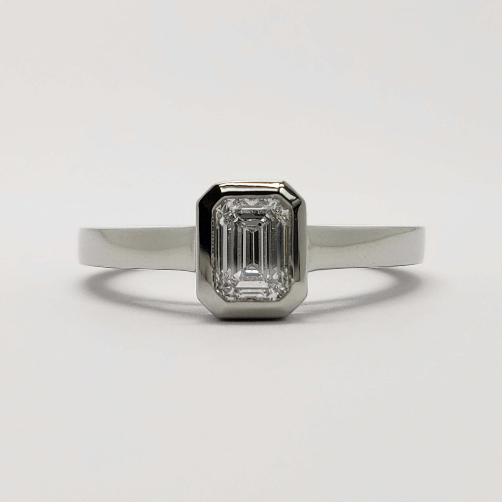 Front view of 14kt white gold ring with emerald cut lab diamond bezel set