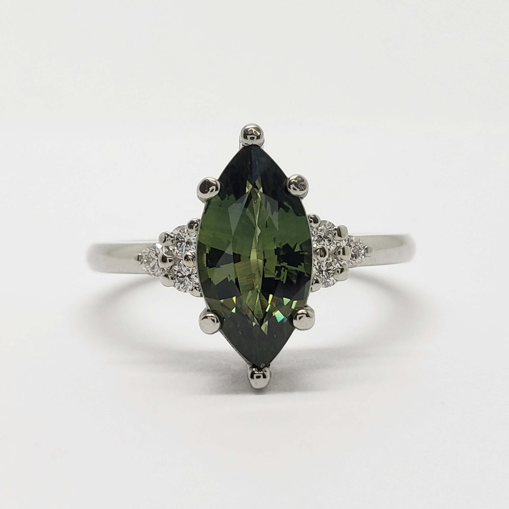 Front view of 14kt white gold ring with marquise green sapphire and diamond clusters