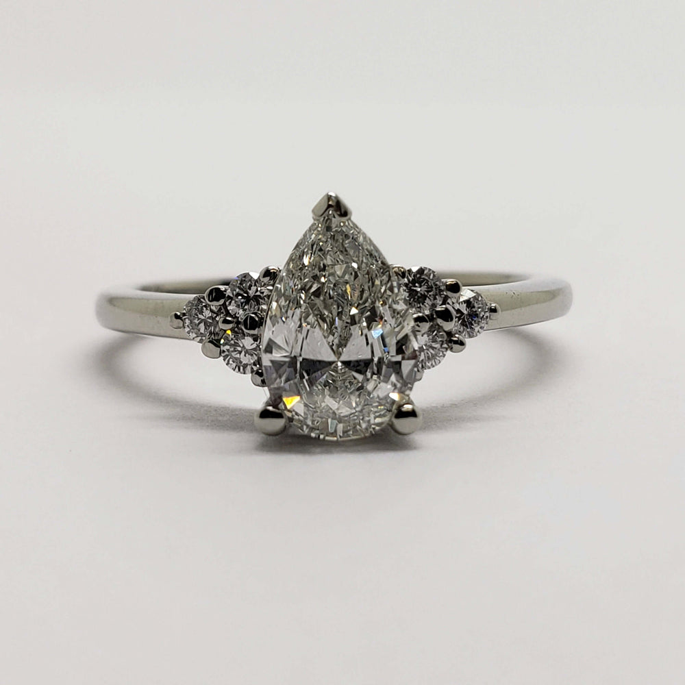 Front view of 14kt white gold ring with pear cut lab diamond and round diamond accents