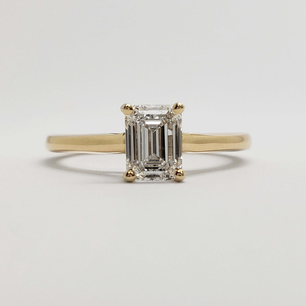 Front view of emerald cut lab diamond solitaire ring in 14kt yellow gold