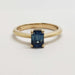 Front view of 14kt yellow gold engagement ring with blue emerald cut Montana sapphire