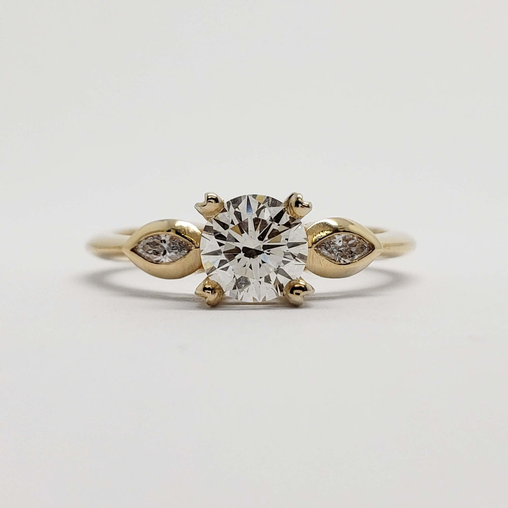 Front view of 14kt yellow gold engagement ring with round lab diamond and marquise side stones