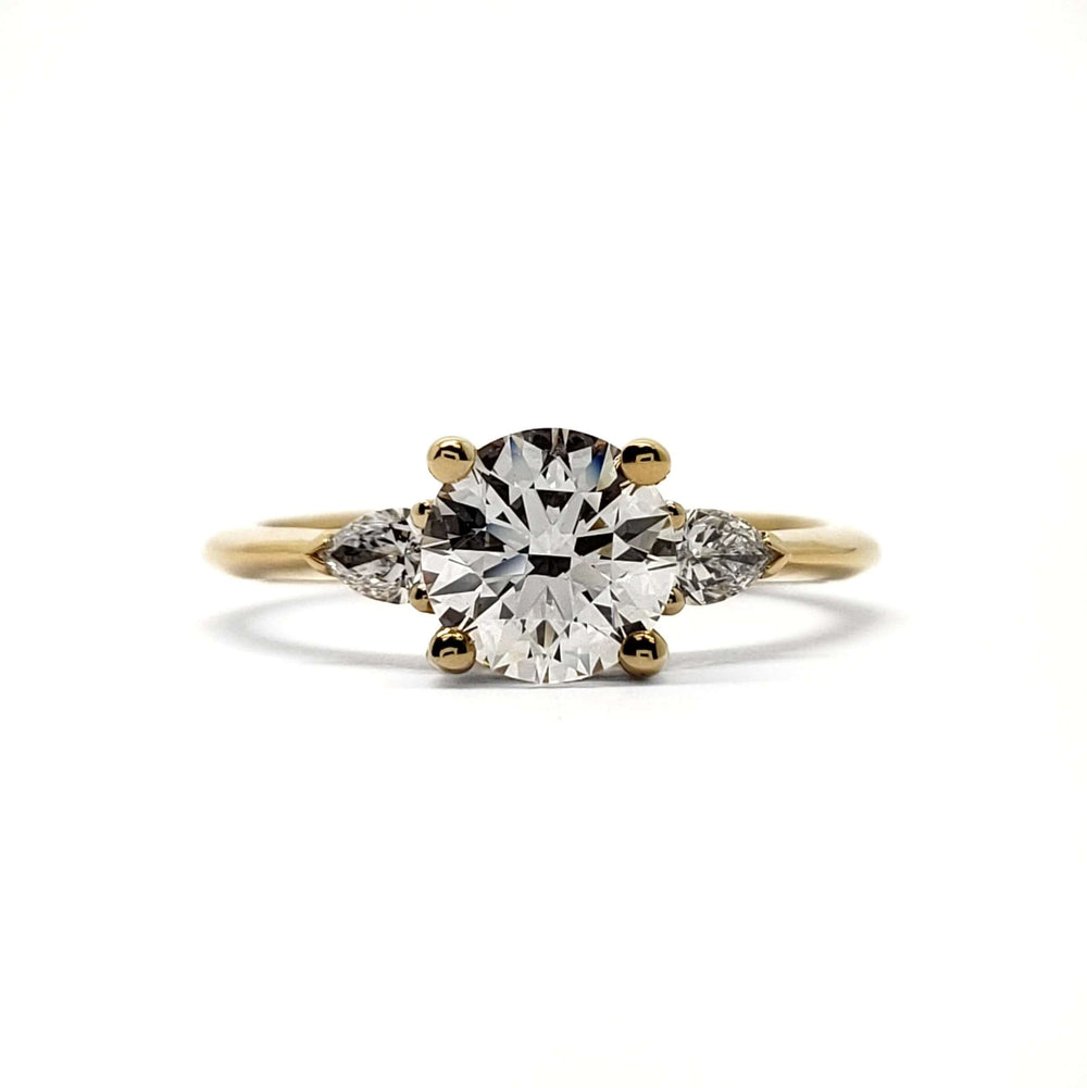 Front view of 14kt yellow gold engagement ring with round lab diamond and pear-shaped accent stones
