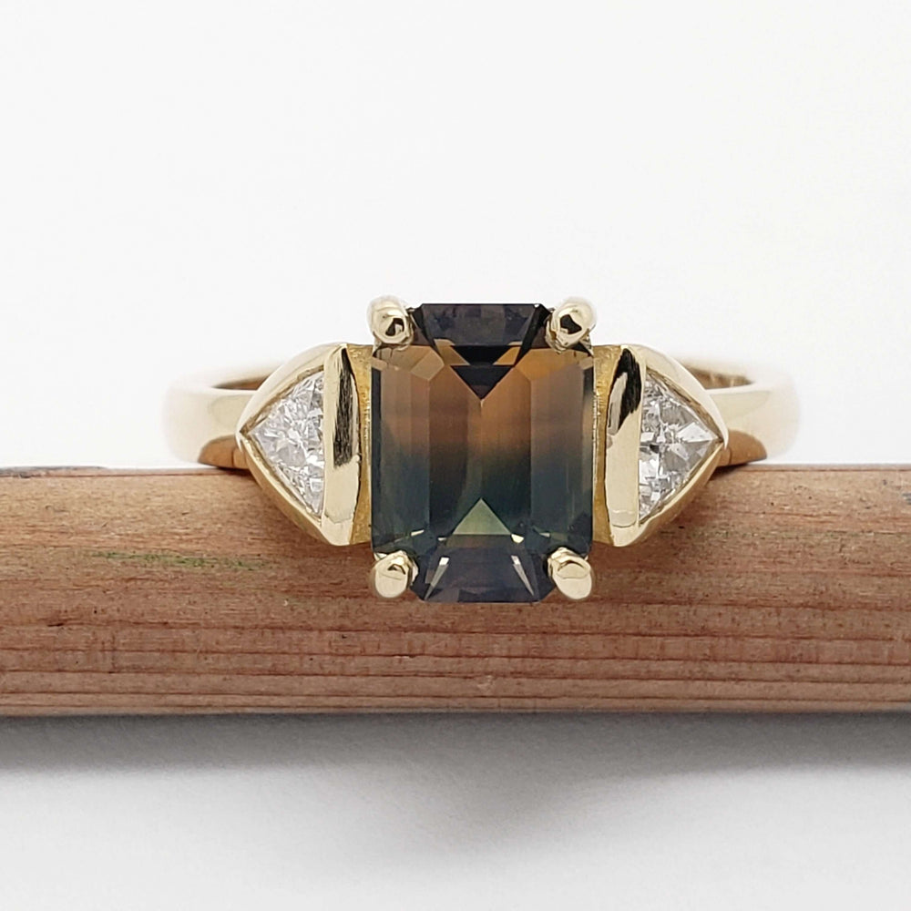 Front view of 14kt yellow gold ring with bi-coloured sapphire and trillion diamonds