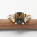 Front view of 14kt yellow gold ring with bi-coloured sapphire and trillion diamonds