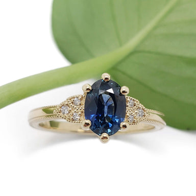 Front view of 14kt yellow gold ring with blue Montana sapphire and diamond accents