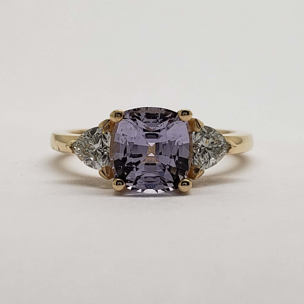 Front view of 14kt yellow gold ring with lavender sapphire and trillion lab diamonds