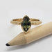 Front view of 14kt yellow gold ring with marquise green sapphire and engraved band