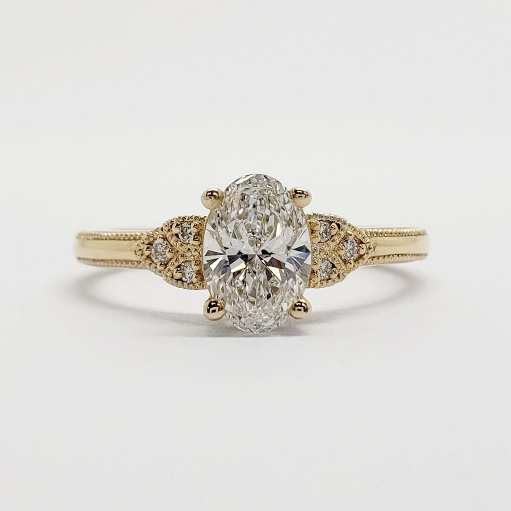 Front view of 14kt yellow gold ring with oval lab grown diamond and accent stones