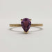 Front view of 14kt yellow gold ring with pear shaped pink sapphire and detailed engraving