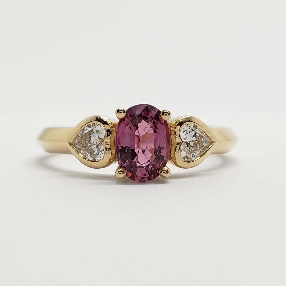 Front view of 14kt yellow gold ring with pink sapphire and heart-shaped lab diamonds