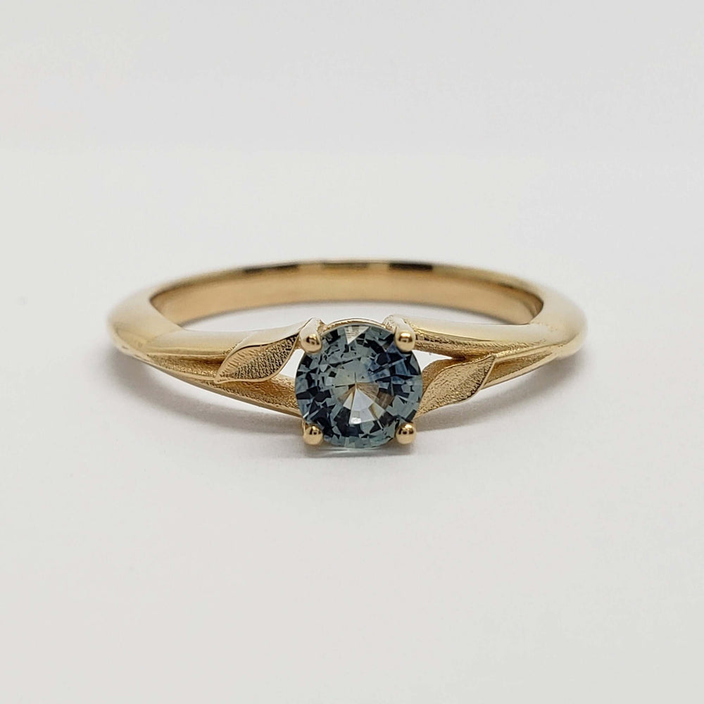 Front view of 14kt yellow gold ring with round teal Montana sapphire