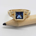 Front view of 14kt yellow gold ring with square blue sapphire and diamond details