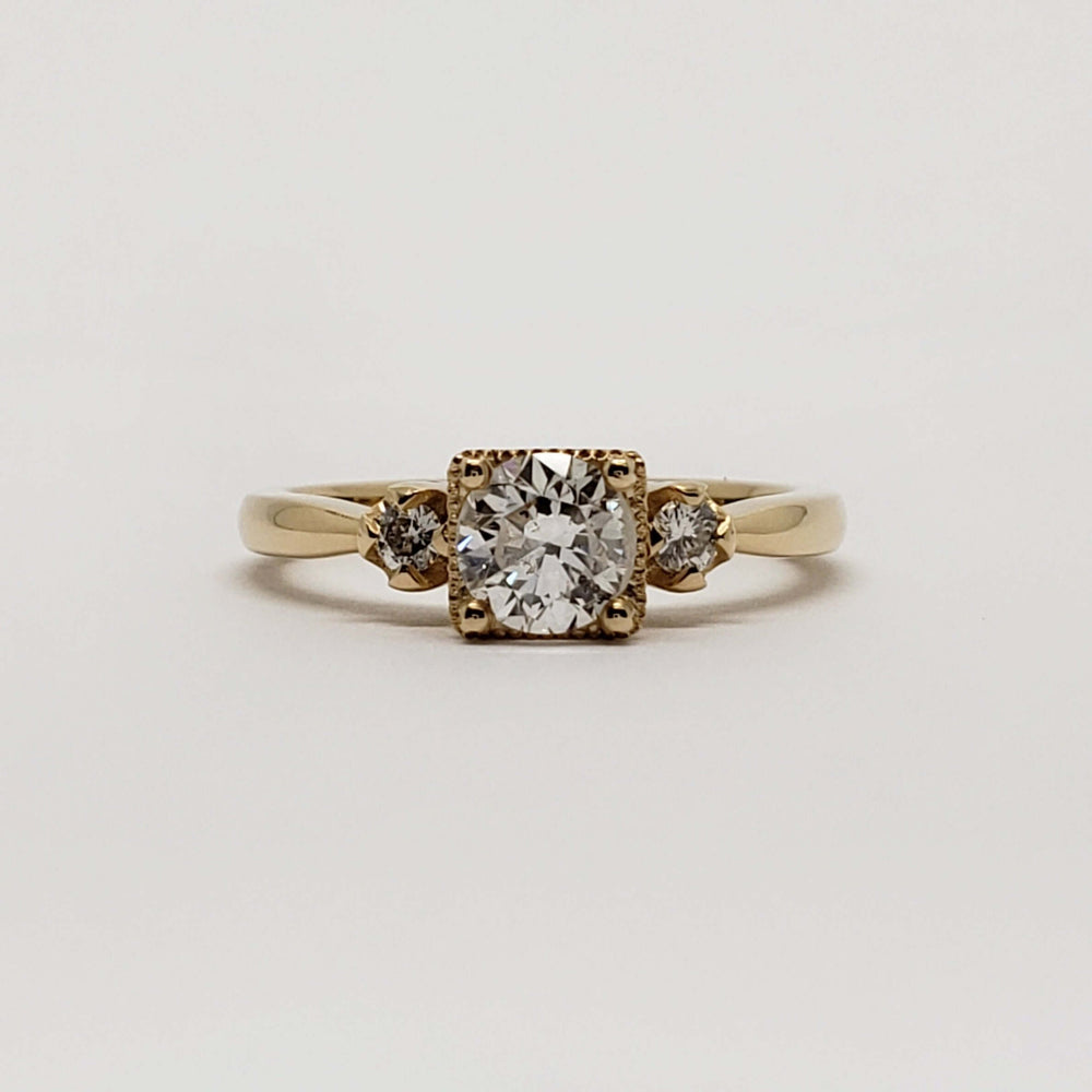 Front view of a 14kt yellow gold engagement ring with three vintage round diamonds