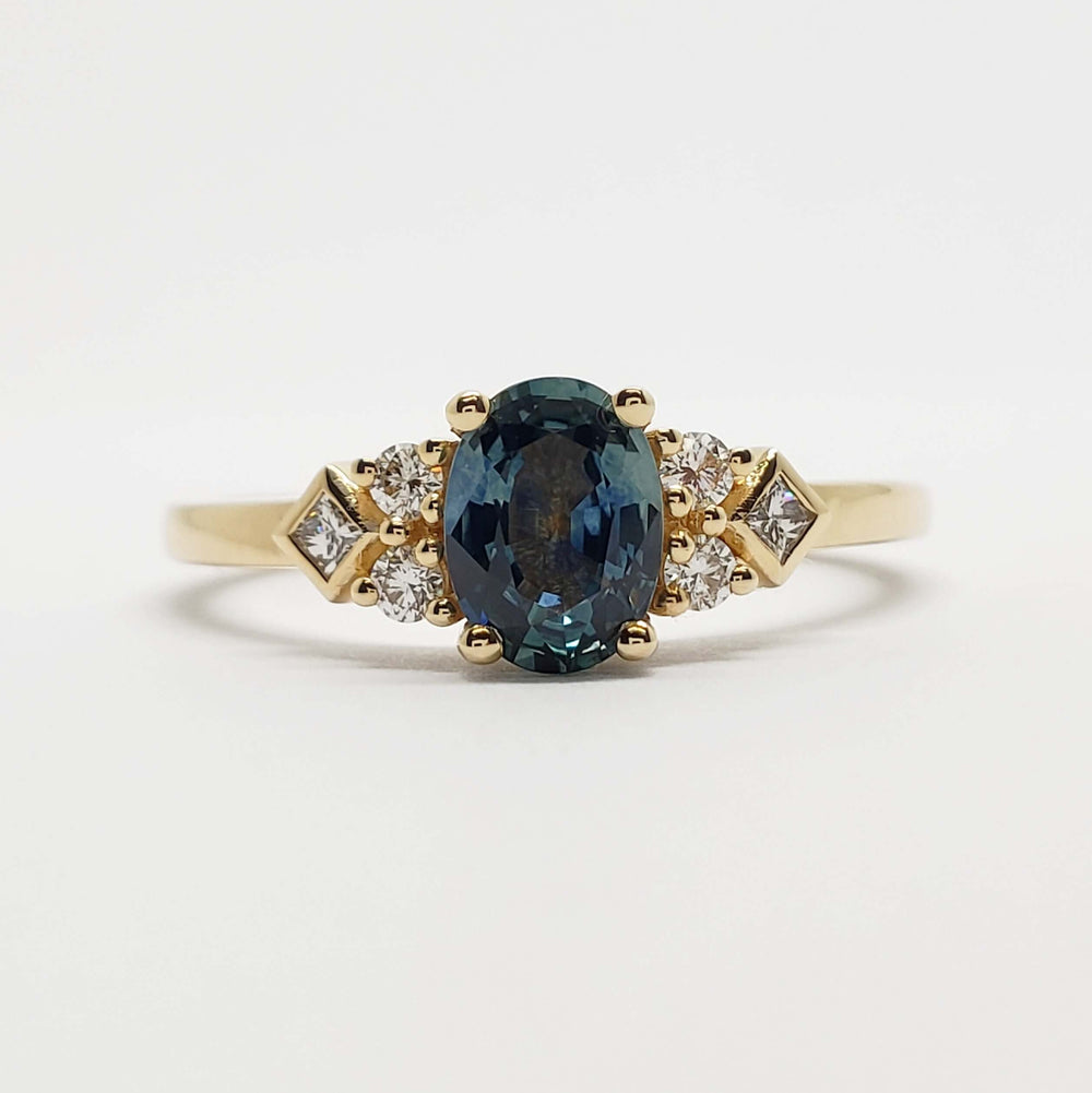 Front view of 14kt yellow gold ring with teal Montana sapphire and diamond accents