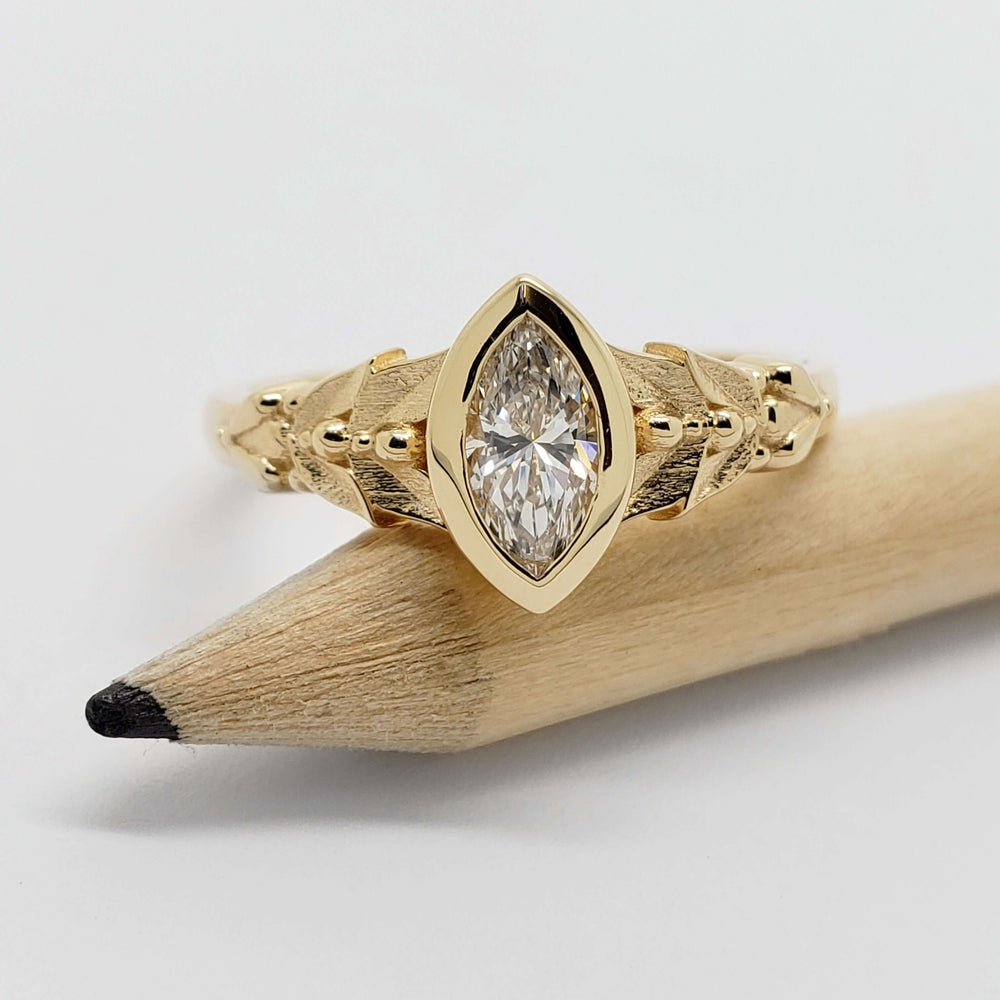 Front view of Oriana 14kt yellow gold ring with marquise lab diamond on a pencil