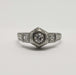 Front view of antique 18kt white gold ring with central round diamond and two princess cut diamonds