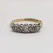 Frontal view of five old-cut diamonds set in platinum atop an 18kt yellow gold band