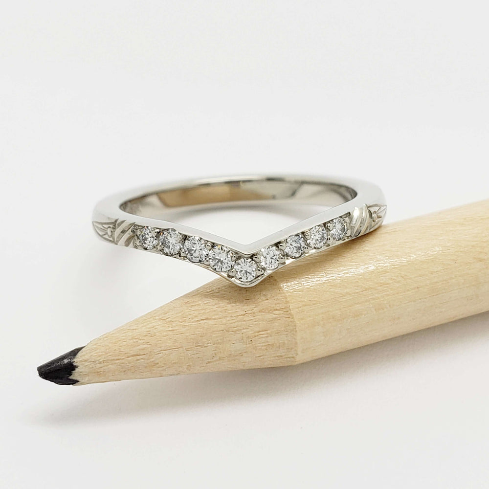 Front view of 14kt white gold chevron wedding ring with pave-set Canadian diamonds on a pencil