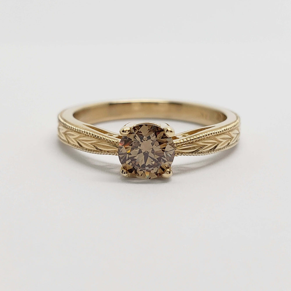 Front view of 14kt yellow gold engagement ring with round champagne diamond and engraved band