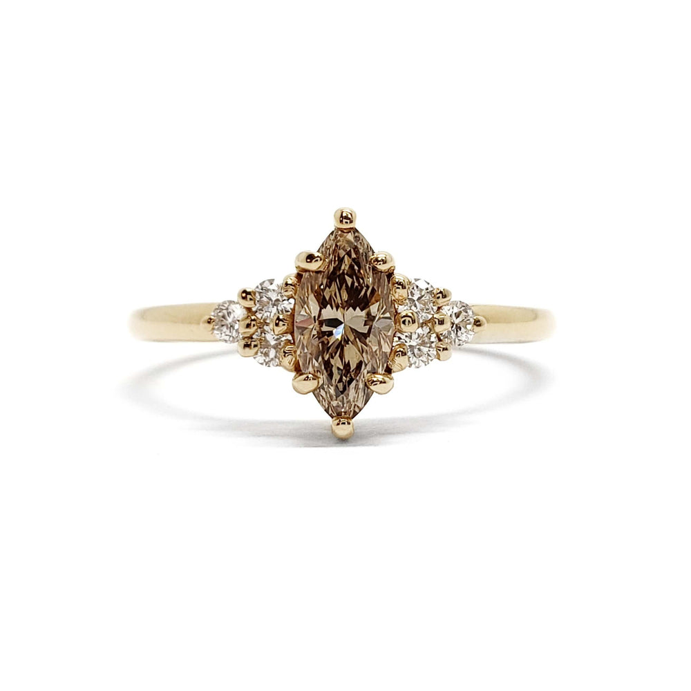 Front view of marquise champagne diamond and accent diamond ring in yellow gold