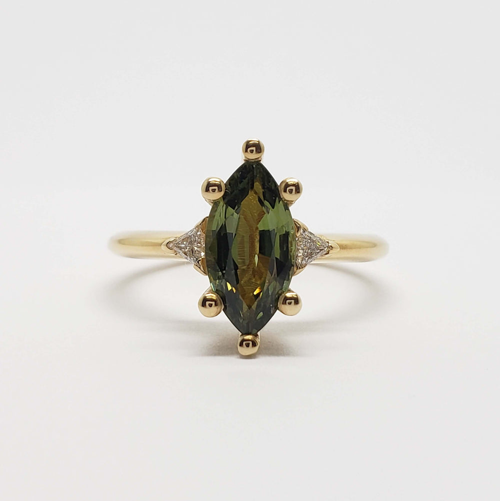 Front view of marquise green sapphire and triangle lab diamond ring in yellow gold