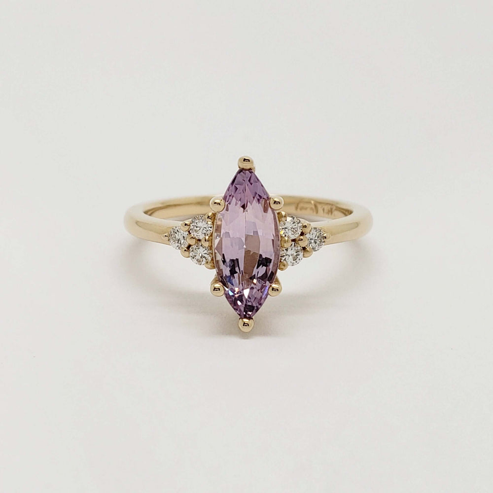 Front view of marquise purple sapphire ring with diamond accents in yellow gold