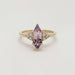 Front view of marquise purple sapphire ring with diamond accents in yellow gold