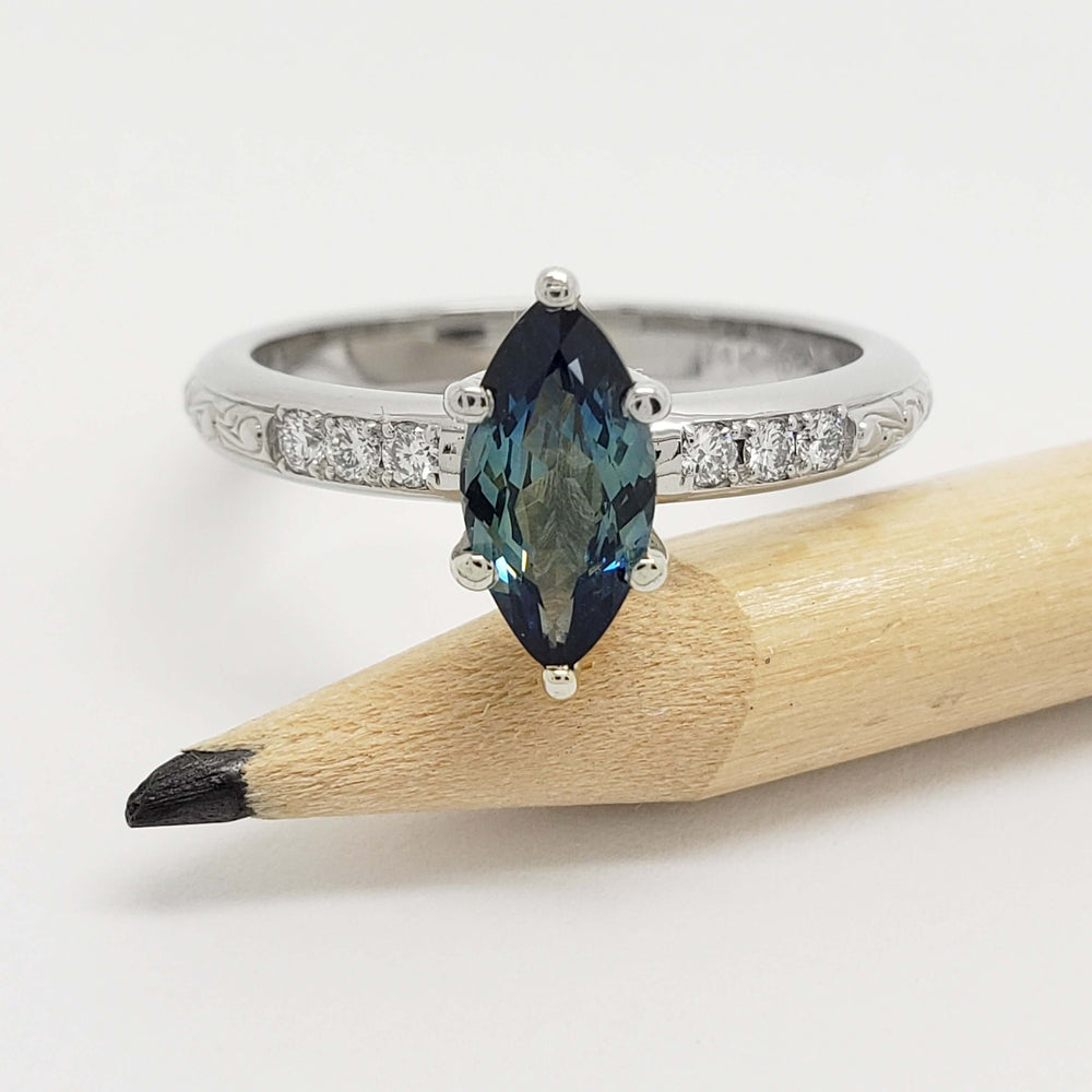 Front view of marquise teal Australian sapphire and diamond ring in white gold, shown with pencil