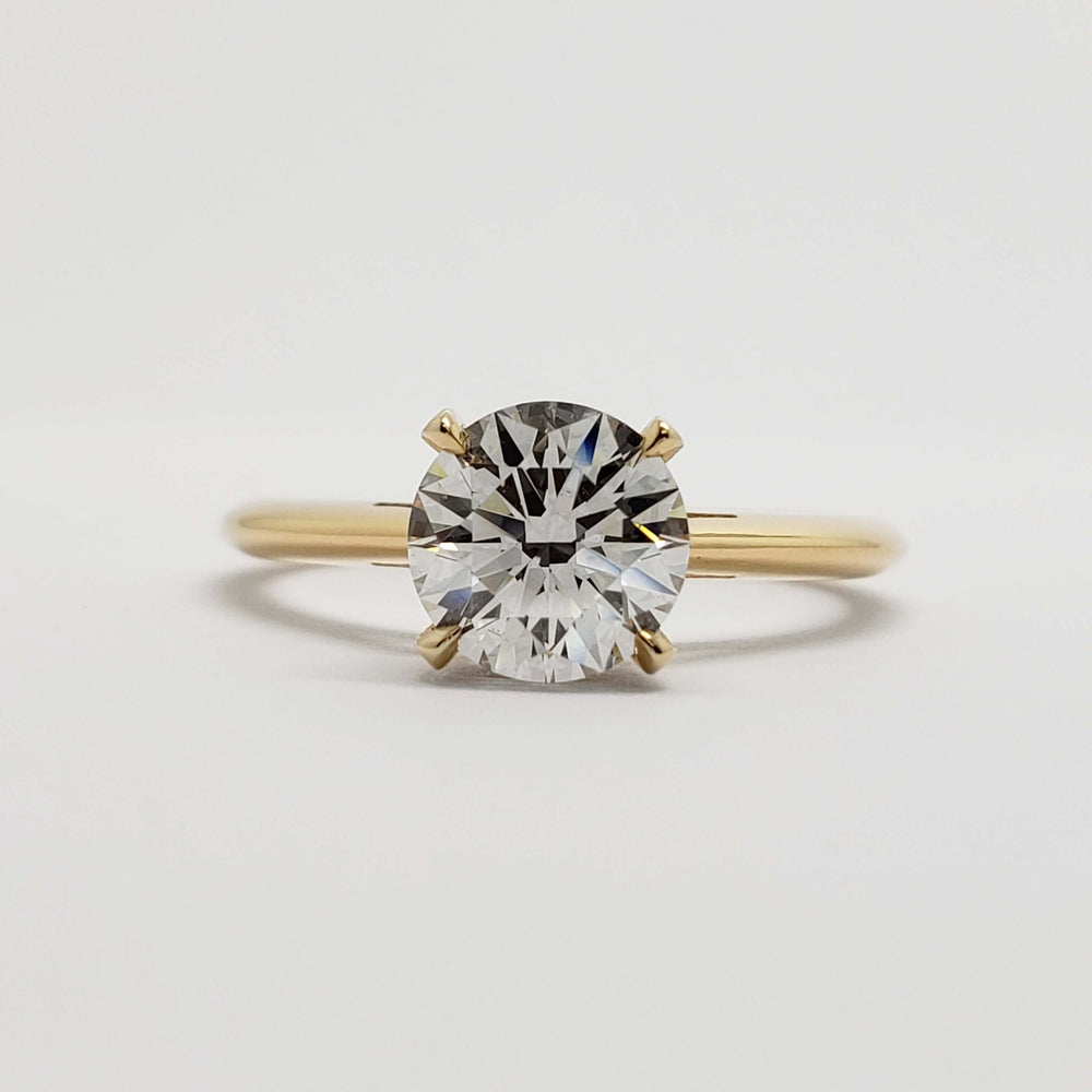 Front view of round lab diamond solitaire engagement ring in yellow gold