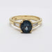 Front view of 14K yellow gold ring with teal Montana sapphire and baguette diamond accents