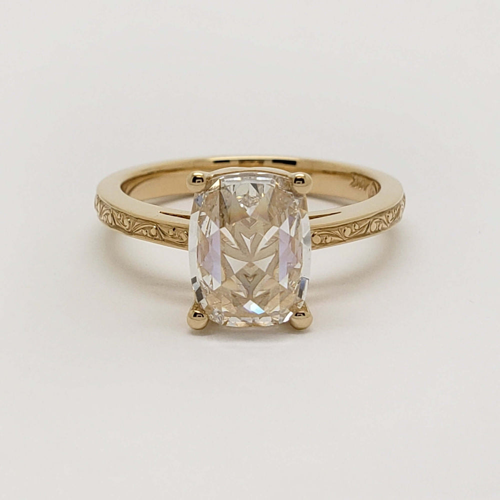 Front view of 14kt yellow gold ring with cushion rose cut lab diamond and engraved band
