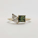 Front view of yellow gold ring with marquise diamond and princess cut teal sapphire