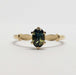 Front view of 14kt yellow gold ring with oval blue-green Australian sapphire and leaf accents