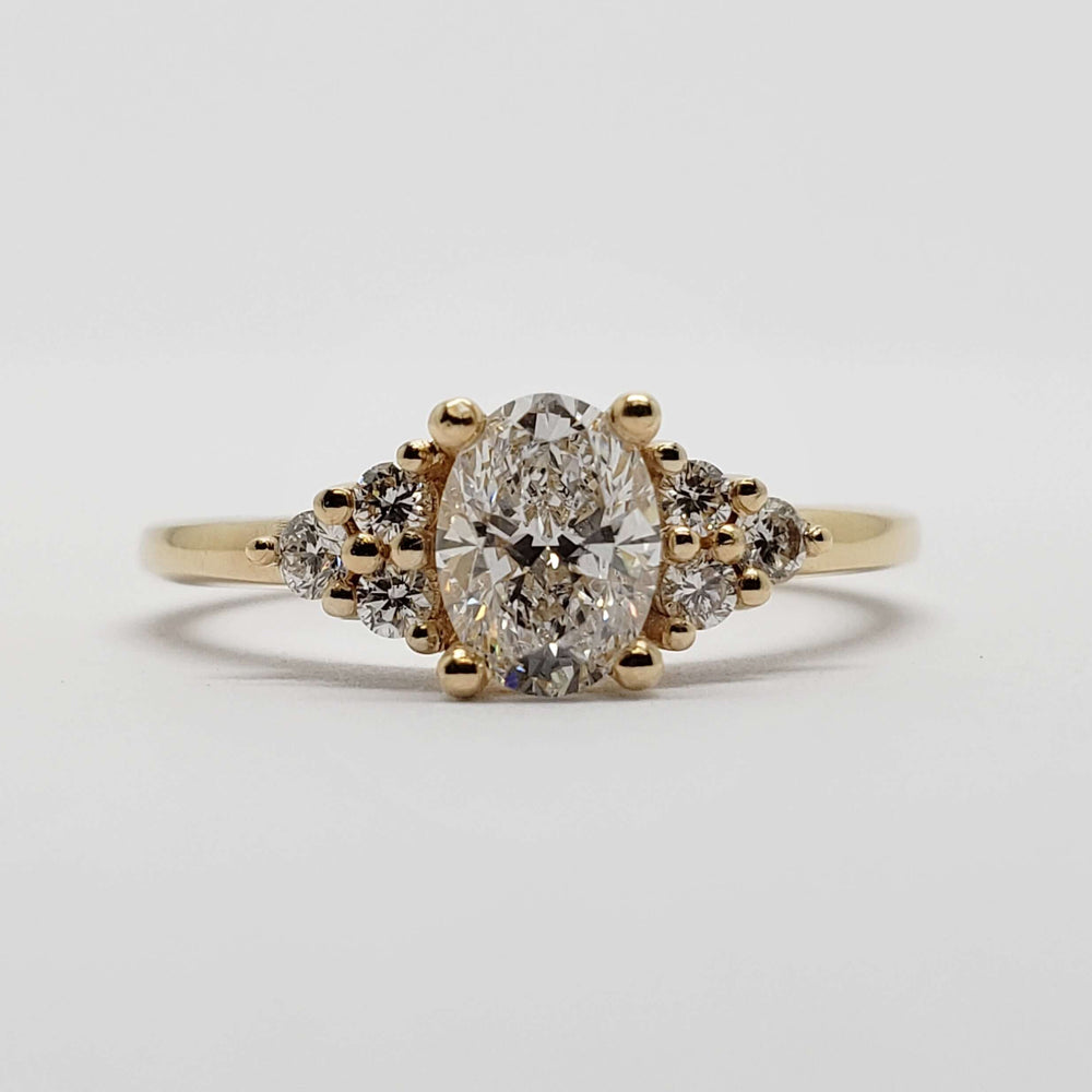 Front view of 14kt yellow gold ring with oval lab diamond and side diamond accents