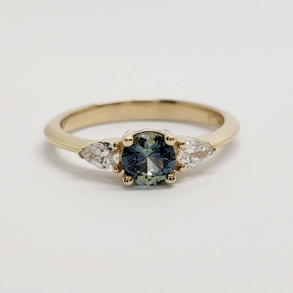 Front view of 14kt yellow gold ring with blue-green sapphire and pear-shaped lab diamonds