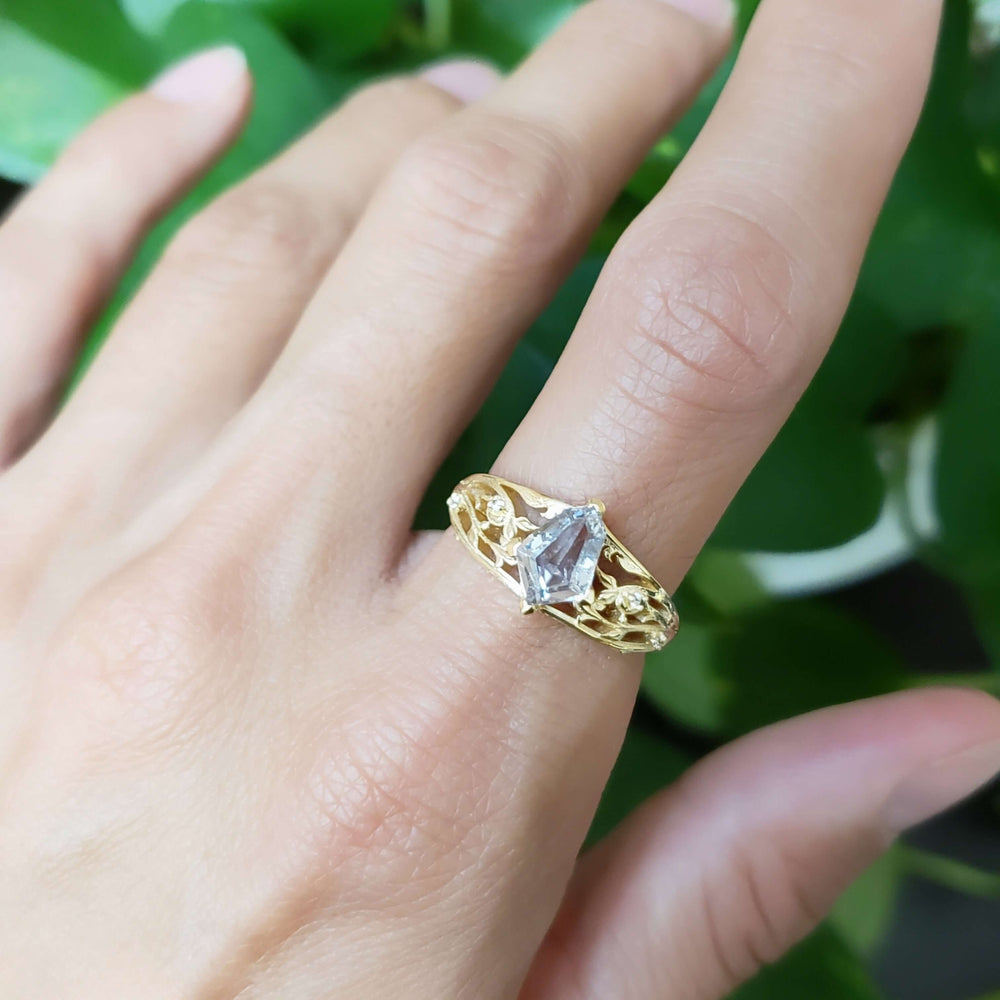 Galadriel engagement ring with shield cut sapphire and filigree, worn on a hand
