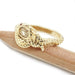Side view of gold snake ring with champagne diamond and ruby eyes, on pencil