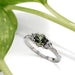 Green Australian sapphire and diamond engagement ring in white gold, shown with greenery