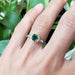 Green Madagascar sapphire and diamond engagement ring in 14k gold, worn on a hand