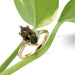 Green sapphire and lab diamond engagement ring in yellow gold, styled with plant