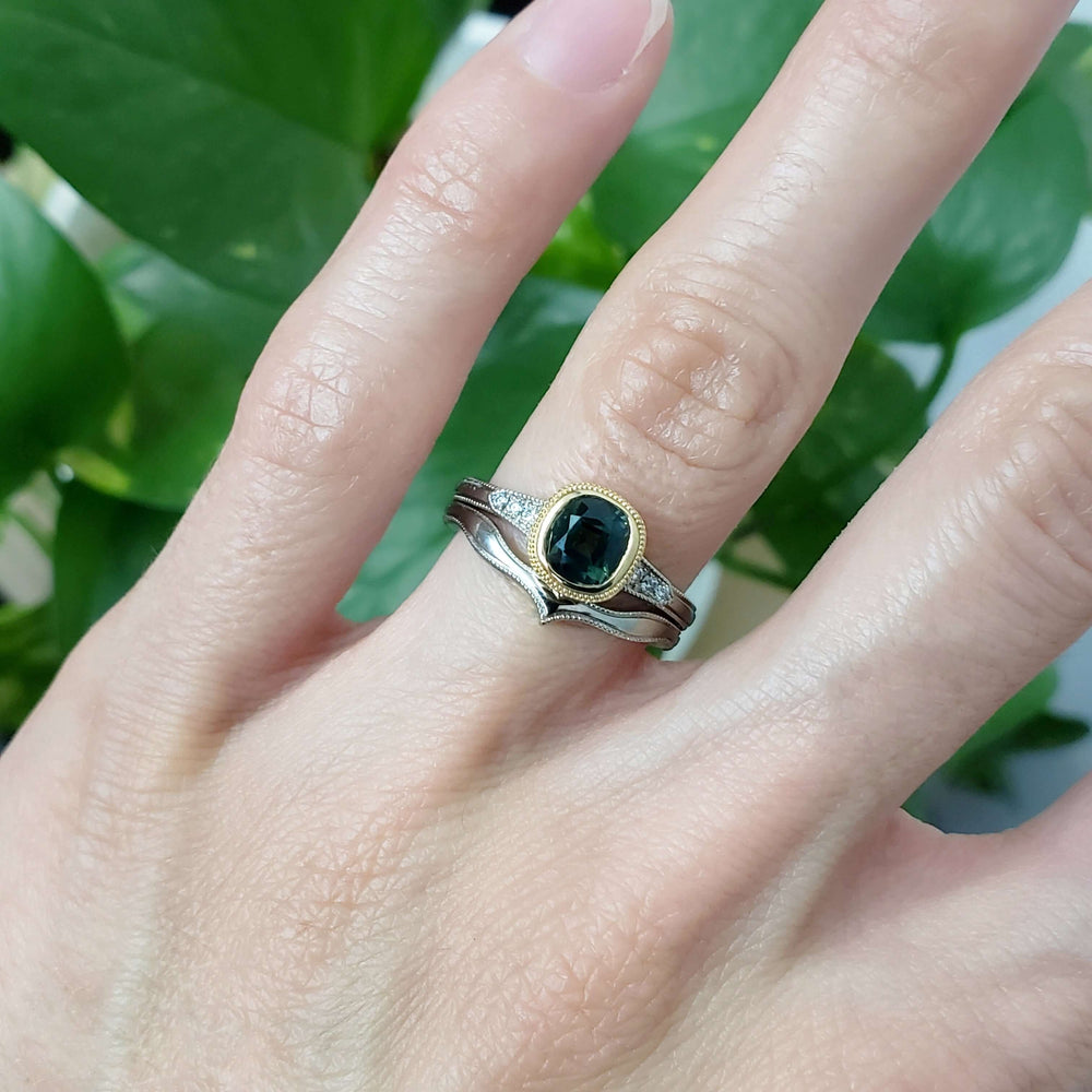 Green sapphire engagement ring in 14k gold with diamond accents, stacked with a chevron band