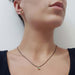 Model wearing 14kt yellow gold green tourmaline stud earrings and pendant necklace