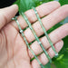 Green tourmaline and white gold bead necklace draped across a hand