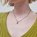 Green tourmaline pendant necklace worn on model with green sweater
