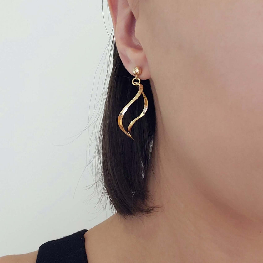 Vintage hammered 14kt yellow gold squiggle hoop earring worn on ear