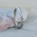 Hand-engraved 14kt white gold wheat wedding band with millgrain, upright on stone