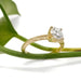 Hand-engraved 14kt yellow gold ring with round lab diamond, shown with green leaf