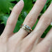 Hand-engraved yellow gold wedding band stacked with three-stone diamond ring on hand